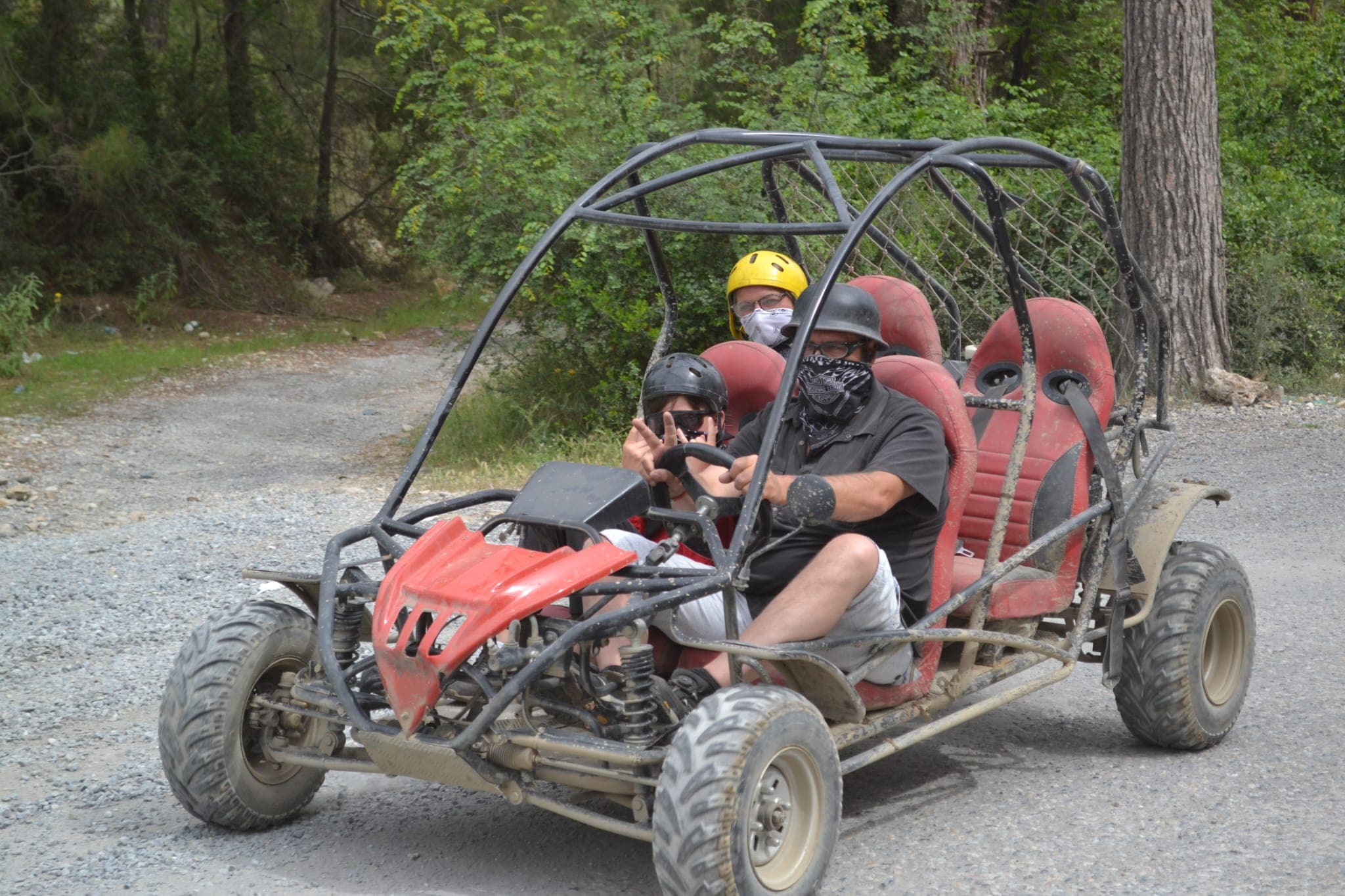 Kırmızı kasklı gençlerin bindiği buggy dereden geçerken su sıçratıyor, içindekiler ıslanmış gülüyor