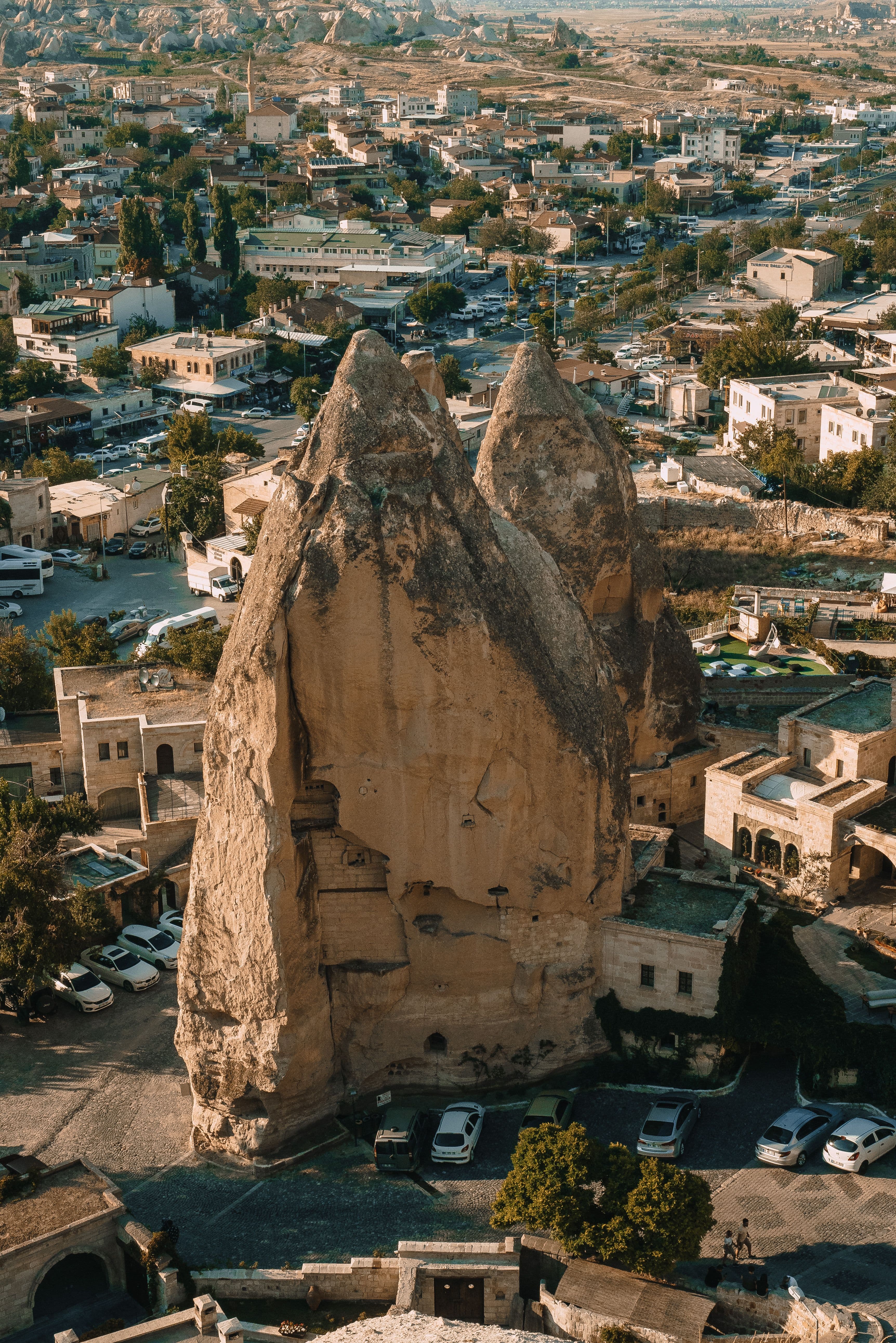 Göreme'nin ortasındaki iki sivri peribacası kasabanın evleri ve sokaklarıyla iç içe yükseliyor, kayanın içine oyulmuş pencereler görünüyor