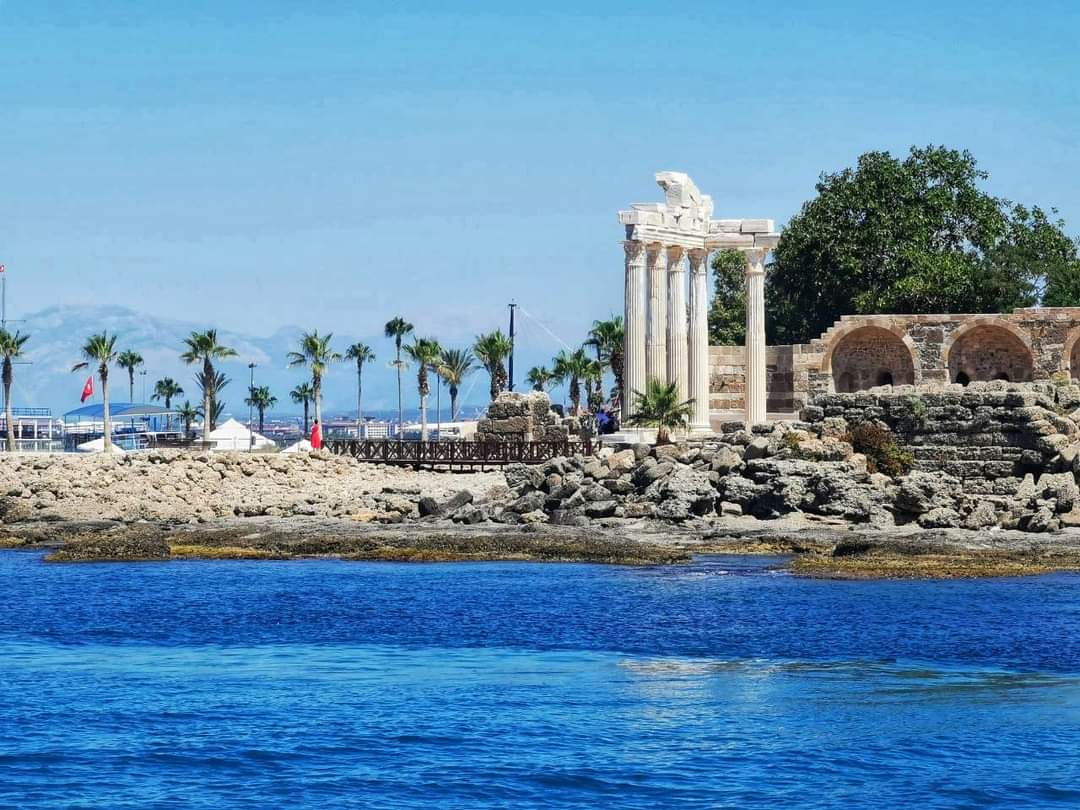 Apollon Tapınağı'nın sütunları deniz kıyısında yükseliyor, önünde kayalıklar ve mavi deniz